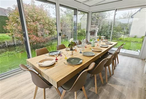 Table dressée dans une véranda ouverte sur le jardin